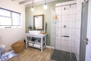 a bathroom with a sink and a shower at Delightful db story loft with airconditioning in Hermanus