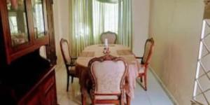 a dining room table with chairs and a candle on it at Portmore Havens 1Bedroom EntireGuest House in Portmore