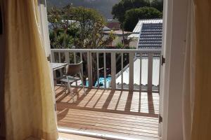 an open door to a balcony with a table and chairs at Delightful db story loft with airconditioning in Hermanus