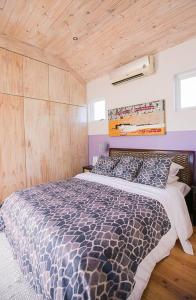 a bedroom with a bed and a wooden ceiling at Delightful db story loft with airconditioning in Hermanus