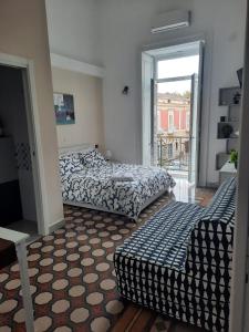 een slaapkamer met 2 bedden, een raam en een bank bij Casa vacanza Luén in Marigliano