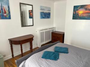 Schlafzimmer mit einem Bett, einem Schreibtisch und einem Spiegel in der Unterkunft Fantastic villa bournemouth - spa, parking, garden in Bournemouth