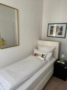 a bedroom with a white bed with a mirror at Hotel Goldenes Lamm in Idstein