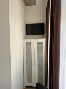 Habitación con TV en la pared y armario. en Hotel Goldenes Lamm, en Idstein