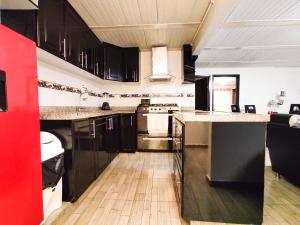 uma cozinha com armários pretos e electrodomésticos de aço inoxidável em Excelente Apto a 10 minutos de el Aeropuerto em Bogotá