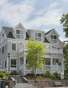 a large white house with a porch at The Grand Hotel in Kennebunk