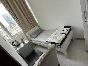 a small bed in a room with a window at Corniche AD - Superb Lovely Room in Abu Dhabi