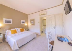um quarto com uma cama branca e uma casa de banho em Hotel Terme Principe em Ischia