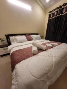 a bedroom with a large bed with two white towels at THE PERFECT STAYS: CHOUDHARY VILLA in Lonavala