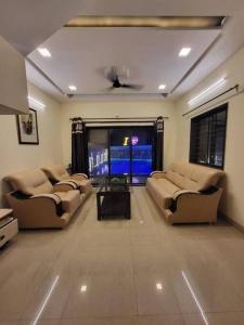 a living room with two couches and a flat screen tv at THE PERFECT STAYS: CHOUDHARY VILLA in Lonavala