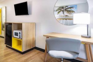 a room with a desk and a chair and a tv at Days Inn by Wyndham Barnwell in Barnwell