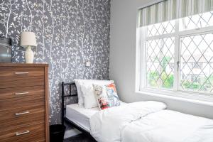 1 dormitorio con cama, ventana y vestidor en Stunning Place, close to Windsor & Heathrow & Private Parking en Burnham