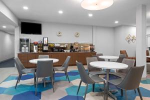 a waiting room with tables and chairs and a bar at Microtel Inn & Suites by Wyndham of Houma in Houma