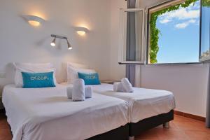 two twin beds in a room with a window at Résidence Belvedere de Palombaggia in Porto-Vecchio