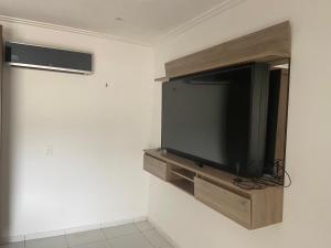 uma televisão de ecrã plano numa parede num quarto em Guilherme Hostel em Fortaleza