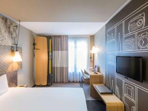 パリにあるイビス パリ ガレ ドゥ リヨン レデュー ローランのベッドとテレビ付きのホテルルーム