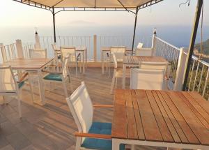 a deck with tables and chairs and a view of the ocean at B&B La Danza del Mare in Anacapri