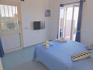 a bedroom with a blue bed with two teddy bears on it at B&B La Danza del Mare in Anacapri