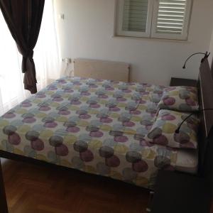 een bed met een dekbed in een slaapkamer bij Apartment Biserka in Cavtat