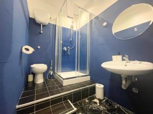 a blue bathroom with a shower and a sink at Prati Boutique Suites in Rome