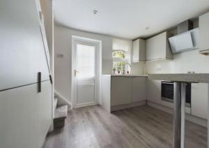 een keuken met witte kasten en een witte deur bij Central Brentwood House in Brentwood