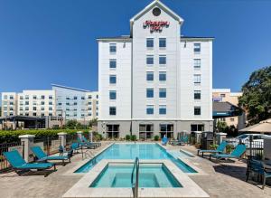 a hotel with a swimming pool and chairs at Hampton Inn Biloxi Beach Boulevard in Biloxi