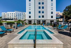 uma piscina com cadeiras e um edifício em Hampton Inn Biloxi Beach Boulevard em Biloxi