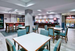 um restaurante com mesas e cadeiras e um bar em Hampton Inn Biloxi Beach Boulevard em Biloxi