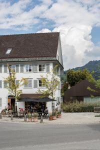 a large white building with tables and chairs in front of it at BAR10ZIMMER in Dornbirn