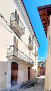 un edificio blanco con 2 balcones en Locanda di Posta en Camarda