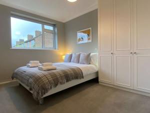 a bedroom with a large bed with a window at Stylish Apartment walk to train 