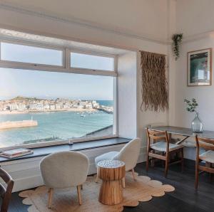 a living room with a large window with a view of the ocean at Harbour View House in St Ives