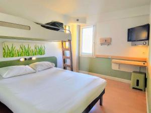 a bedroom with a bunk bed and a television at Ibis Budget Toulon Centre in Toulon