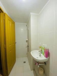 a bathroom with a sink and a yellow door at 4138 Davao City 2bedroom unit 8 Spatial Maa by Filinvest in Davao City