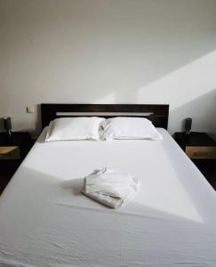 een wit bed met een handdoek erop bij Big and Modern Apartment in Timisoara North T34 in Timişoara