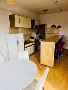 een keuken met een witte koelkast en een tafel en stoelen bij Big and Modern Apartment in Timisoara North T34 in Timişoara