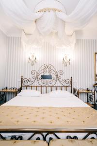 a bedroom with a large bed with white drapes at SPA-Hotel Dodo in Zhytomyr +75 photos