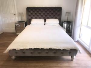 1 dormitorio con 1 cama grande con sábanas y almohadas blancas en MULBERRY LODGE en Woodridge
