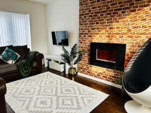 sala de estar con chimenea de ladrillo y sofá en A Stones Throw From The Beach! en Vickerstown