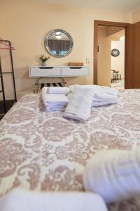 1 dormitorio con cama con almohadas y espejo en ZafireniaSuites en Elevtheraí
