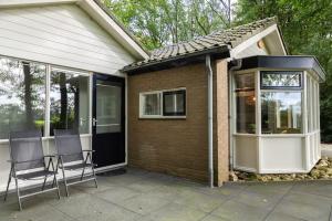 een patio met 2 stoelen en een huis bij Boshiem in Bakkeveen