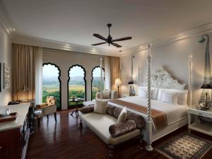Fairmont Jaipur في جايبور: غرفة نوم كبيرة مع سرير وأريكة