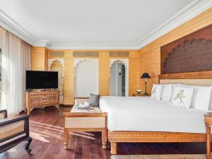 Fairmont Jaipur في جايبور: غرفة نوم بسرير كبير وتلفزيون بشاشة مسطحة