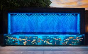 a blue aquarium with a large tank of fish at DoubleTree By Hilton Shenzhen Nanshan Hotel & Residences in Shenzhen