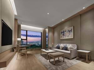 uma sala de estar com um sofá e uma televisão em DoubleTree By Hilton Shenzhen Nanshan Hotel & Residences em Shenzhen