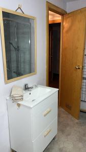 ビリャヌアにあるApartamento Selva Blancaの白い洗面台と鏡のあるバスルーム +6枚の写真