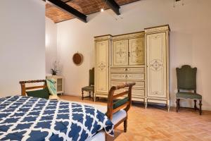 - une chambre avec une grande armoire en bois et 2 chaises dans l'établissement Tenuta di Megognano, à Poggibonsi