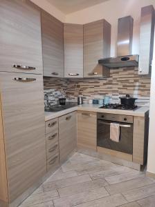 a kitchen with wooden cabinets and a stove top oven at Sant' Andrea 7 in Tivoli