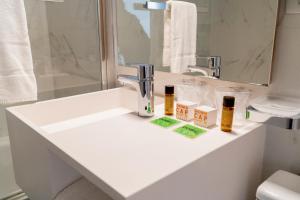 een badkamer met een wastafel met twee flessen erop bij Hotel d'Alcantara in Tournai