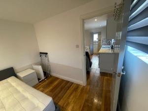 a small room with a bed and a kitchen at One Bedroom Annex with Private Entrance in Morden